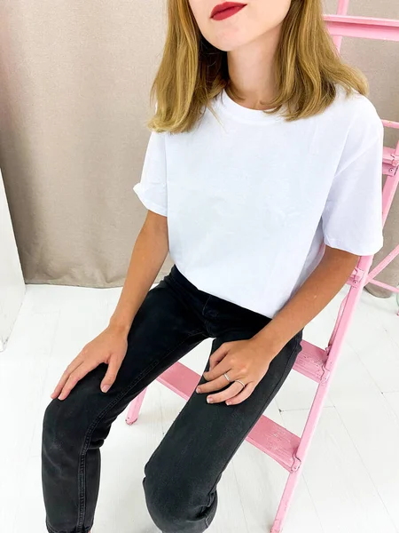 Schöne junge Frau in weißem T-Shirt und schwarzer Jeans — Stockfoto