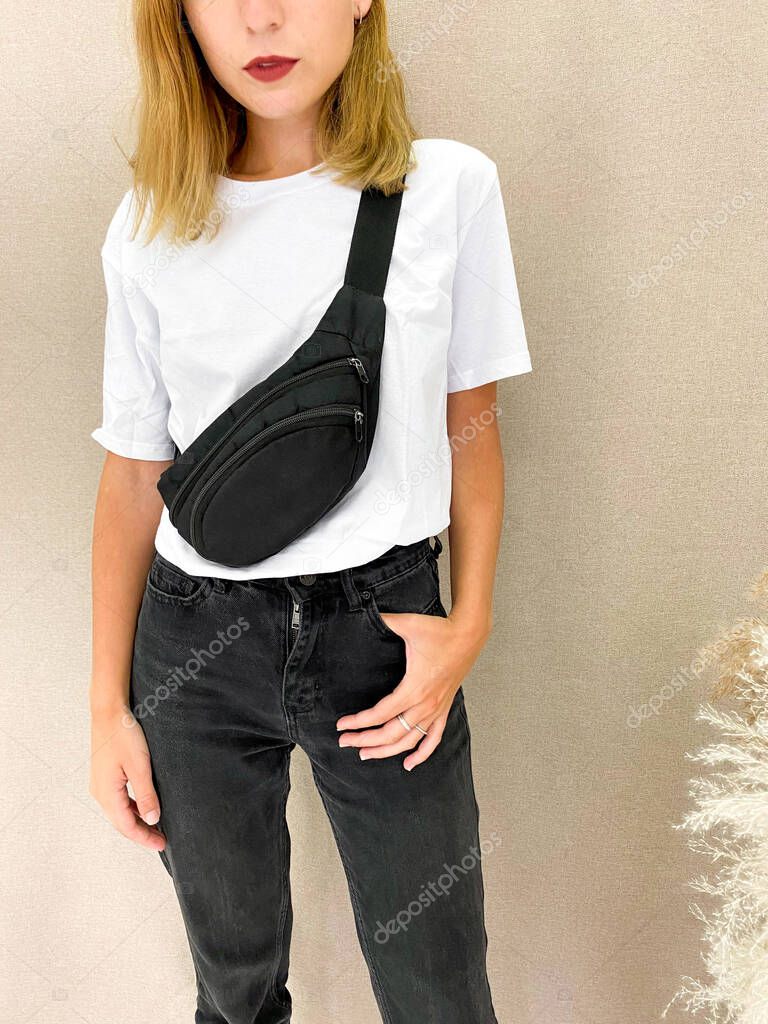 Download Beautiful Young Woman In Blank White T Shirt And Black Jeans Caucasian Model Girl With Blond Hair Wearing Basic Clothing And A Sling Bag Template For Mockup Or Fashion Advertising Premium Stock