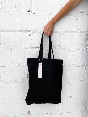 Kadınların elinde yeni siyah bir çanta ya da boş etiketli bir müşteri var.