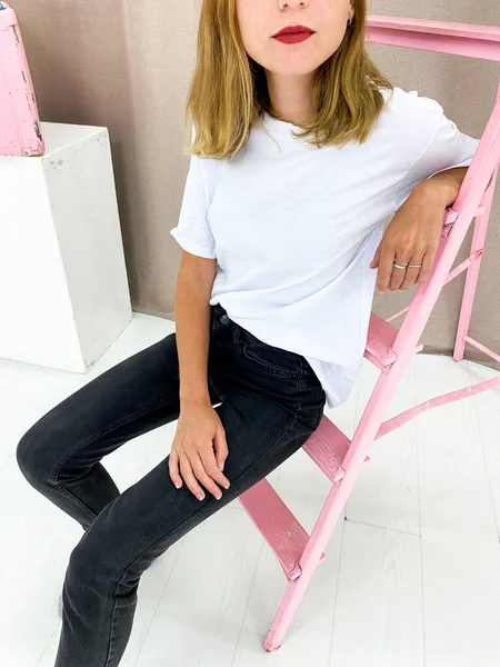 Schöne junge Frau in weißem T-Shirt und schwarzer Jeans — Stockfoto