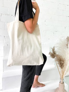 Siyah tişörtlü, kot pantolonlu, çantalı ya da alışveriş yapan güzel bir kadın.