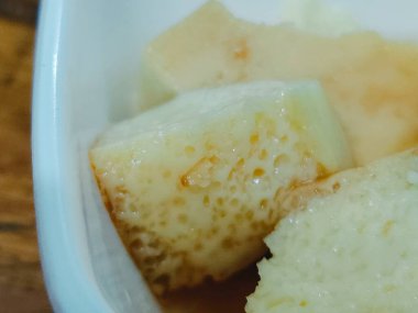 Hafif bir tatlı ya da kahvaltılık bir lokma olduğunu düşündüren, içinde hava deliklerinin olduğu soluk sarı kek küpleri olan bir makro çekim. Yemek tasarımı, yemek tarifleri ve abur cubur tasvirleri için ideal..