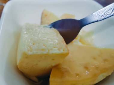 Hafif bir tatlı ya da kahvaltılık bir lokma olduğunu düşündüren, içinde hava deliklerinin olduğu soluk sarı kek küpleri olan bir makro çekim. Yemek tasarımı, yemek tarifleri ve abur cubur tasvirleri için ideal..