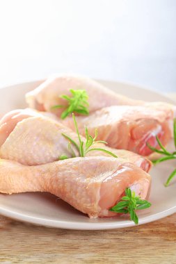 Kırsal arka planda çiğ tavuk budu, biber ve maydanoz.