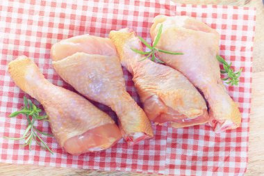 Kırsal arka planda çiğ tavuk budu, biber ve maydanoz.