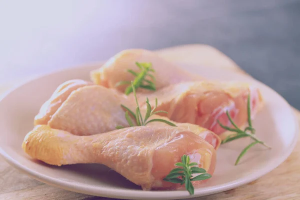 raw chicken thigh, pepper and parsley on rustic background