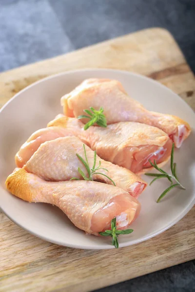 raw chicken thigh, pepper and parsley on rustic background