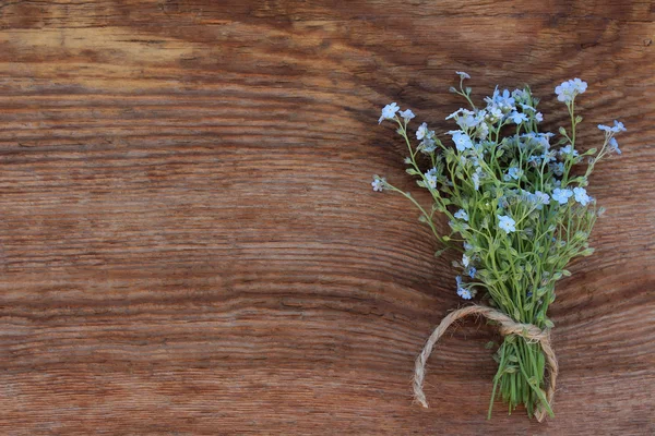 Bouquet of forget-me-nots on an old wooden background — Stock Photo, Image