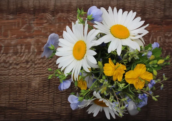 White jug with bouquet of meadow flowers on a wooden background — Stock Photo, Image