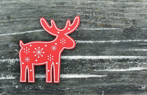 Red deer with white snowflakes and snowdrifts on an old wooden b — Stock Photo, Image