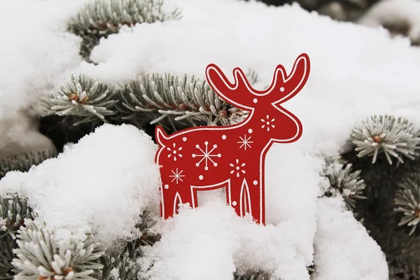 La decoración del árbol de Navidad el ciervo rojo (el alce) sobre la nieve sobre el abeto Imagen de archivo