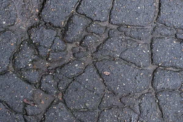 割れアスファルトの暗い質感 壊れた道路 — ストック写真
