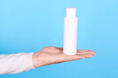 Beyaz losyon şişeli el..