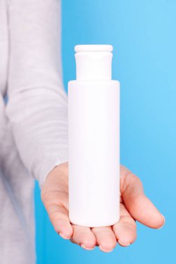 Beyaz losyon şişeli el..