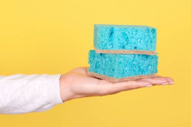 Turkuaz temizleme süngeriyle el..