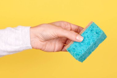 Turkuaz temizleme süngeriyle el..