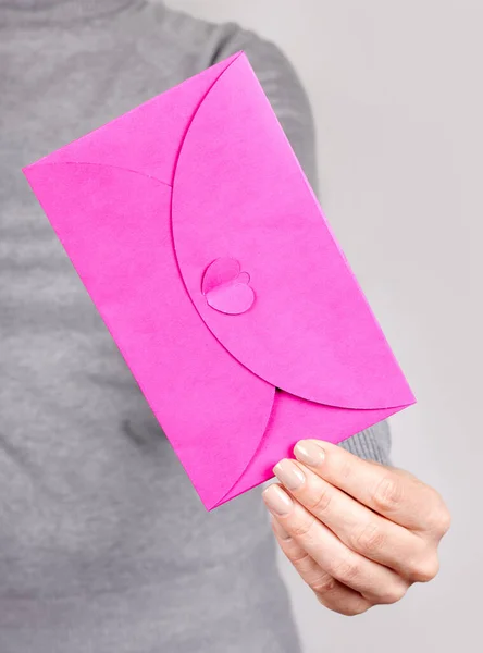 Main Avec Enveloppe Papier Rose Sur Gris — Photo