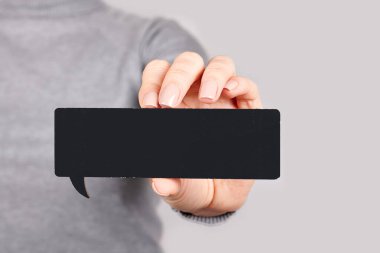 Gri üzerinde siyah ahşap tabela olan el..