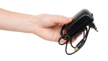 Siyah güç adaptörüyle el beyaza izole edilmiş..