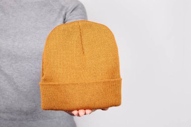 Elleri turuncu kışlık gri şapkalı..