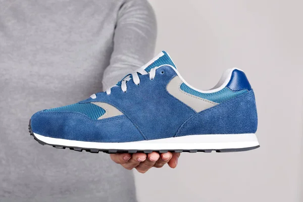 Mano Con Zapato Deportivo Azul Sobre Gris — Foto de Stock