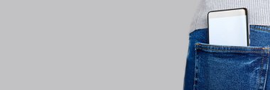 Gri üzerinde kot pantolon cebinde cep telefonu.