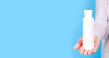 Beyaz losyon şişeli el..