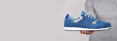 Gri üzerine mavi spor ayakkabıyla el..