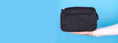 Siyah kozmetik çantalı bir el..