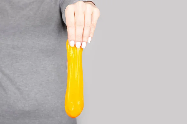 Mão Com Brinquedo Lodo Amarelo Cinza — Fotografia de Stock