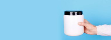 Beyaz kozmetik şişeli el..