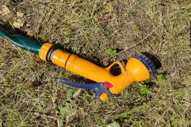 Kuru çimenlerin üzerinde portakal suyu sprey tabancası