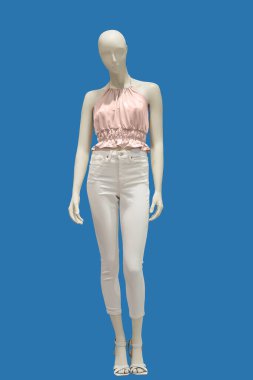 Modaya uygun yaz kıyafetleri giymiş, mavi arka planda izole edilmiş uzun boylu kadın mankeni. Marka isimleri veya telif hakkı nesneleri yok.