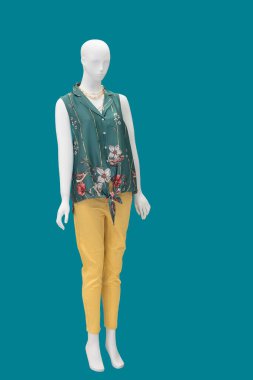 Mavi arka planda izole edilmiş şık kıyafetler giyen bir kadın vitrin mankeni..