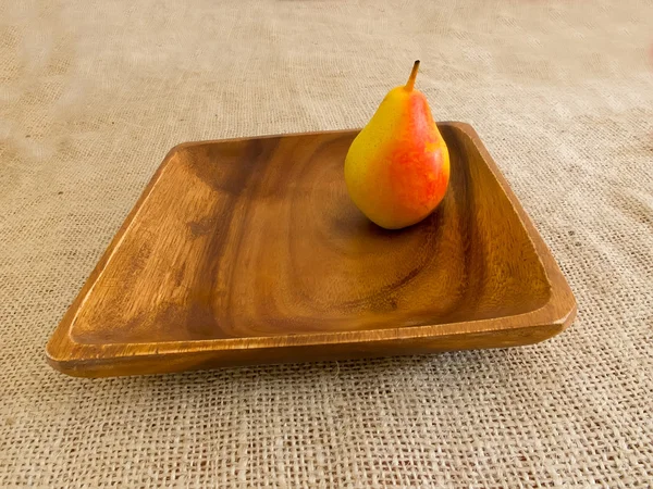 Груша на деревянной тарелке — стоковое фото