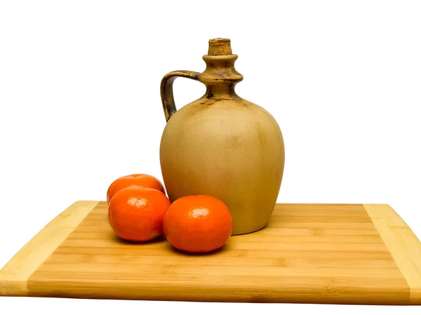 Clay jug on a wooden board — Stock Photo, Image
