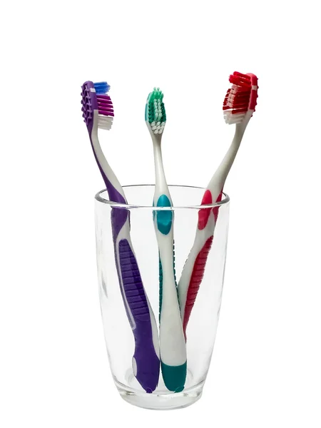 Cepillos de dientes coloridos en vidrio — Foto de Stock