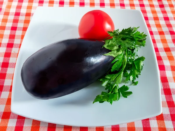 Eggplant tomato and parsley in a plate — Stock Photo, Image