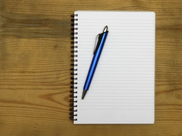 Cuaderno y pluma sobre tabla de madera — Foto de Stock