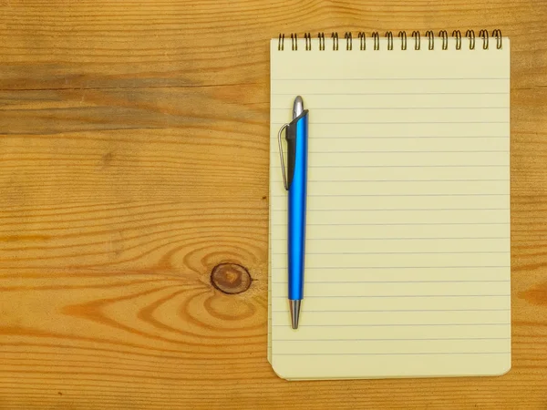 Cuaderno y pluma sobre tabla de madera — Foto de Stock