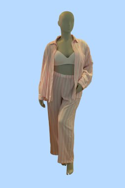 Mavi arka planda pembe çizgili pijama giyen bir kadın vitrin mankeni.