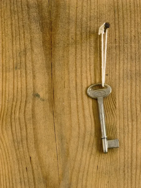 Old key on a wooden board — Stock Photo, Image