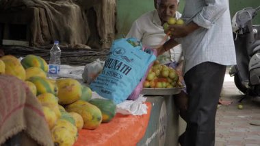 Elderly Vendor at Market Selling Fresh Produce