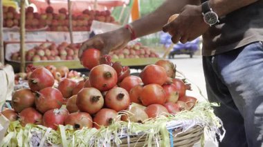 Canlı meyve standında taze elmalara uzanan el.