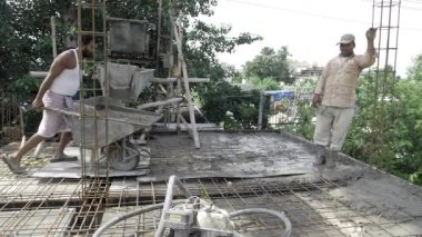 İnşaat işçisi inşaat iskelesi ve çimento karıştırma alanında