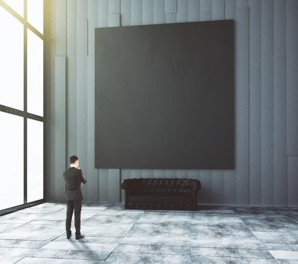 Empresario mira en blanco imagen negraen habitación moderna con leat — Foto de Stock