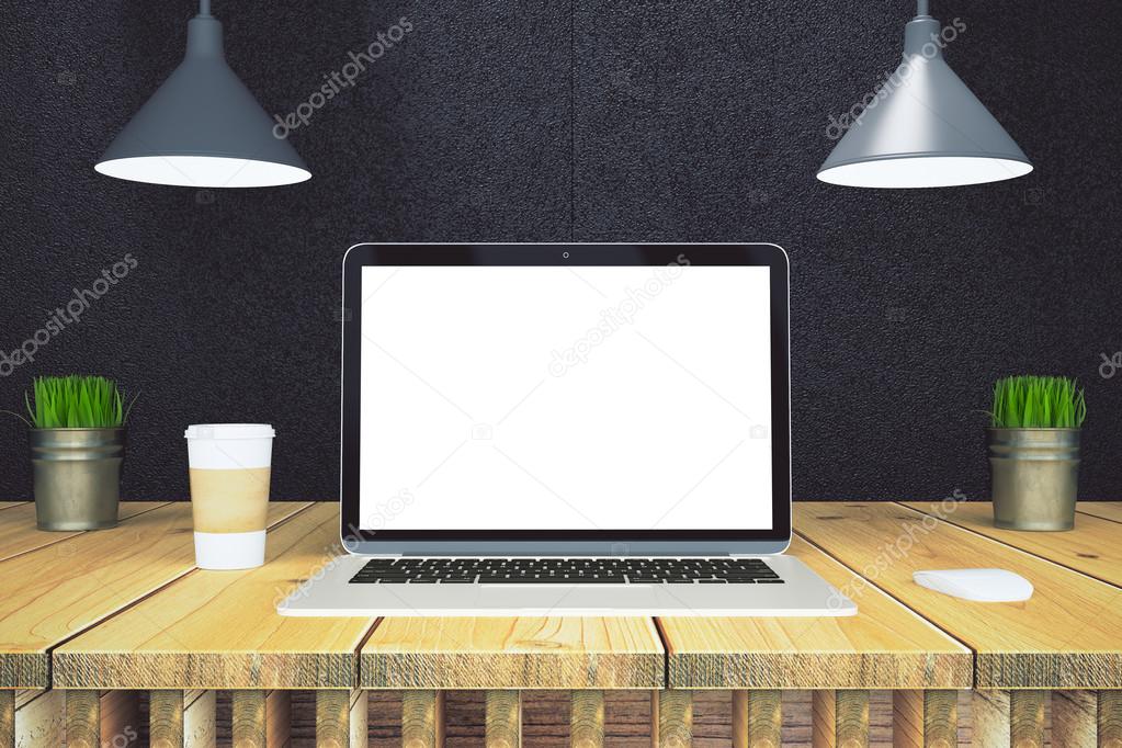 Blank laptop screen on wooden table