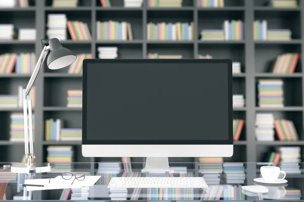 Pantalla de computadora en blanco en la mesa vidriosa en el fondo de la librería, mo — Foto de Stock