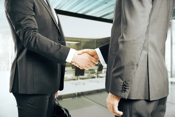 Два бізнесмени тремтять руками на офісному тлі — стокове фото
