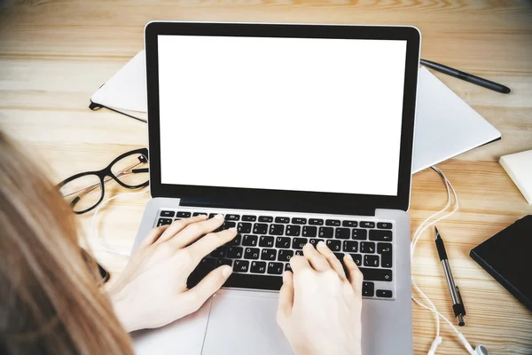 Menina digitando no laptop com tela em branco, óculos, fones de ouvido e — Fotografia de Stock